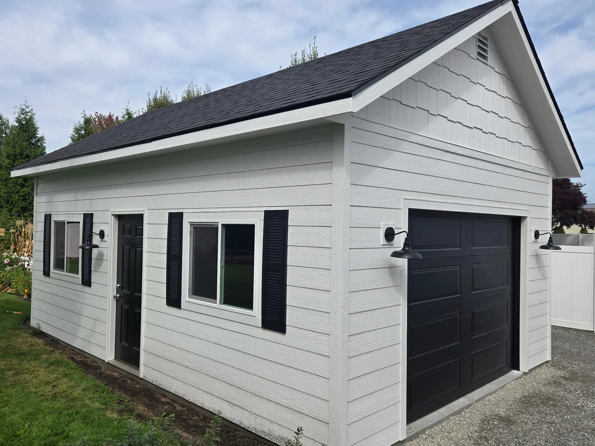 finished shed with garage door and white lap siding
