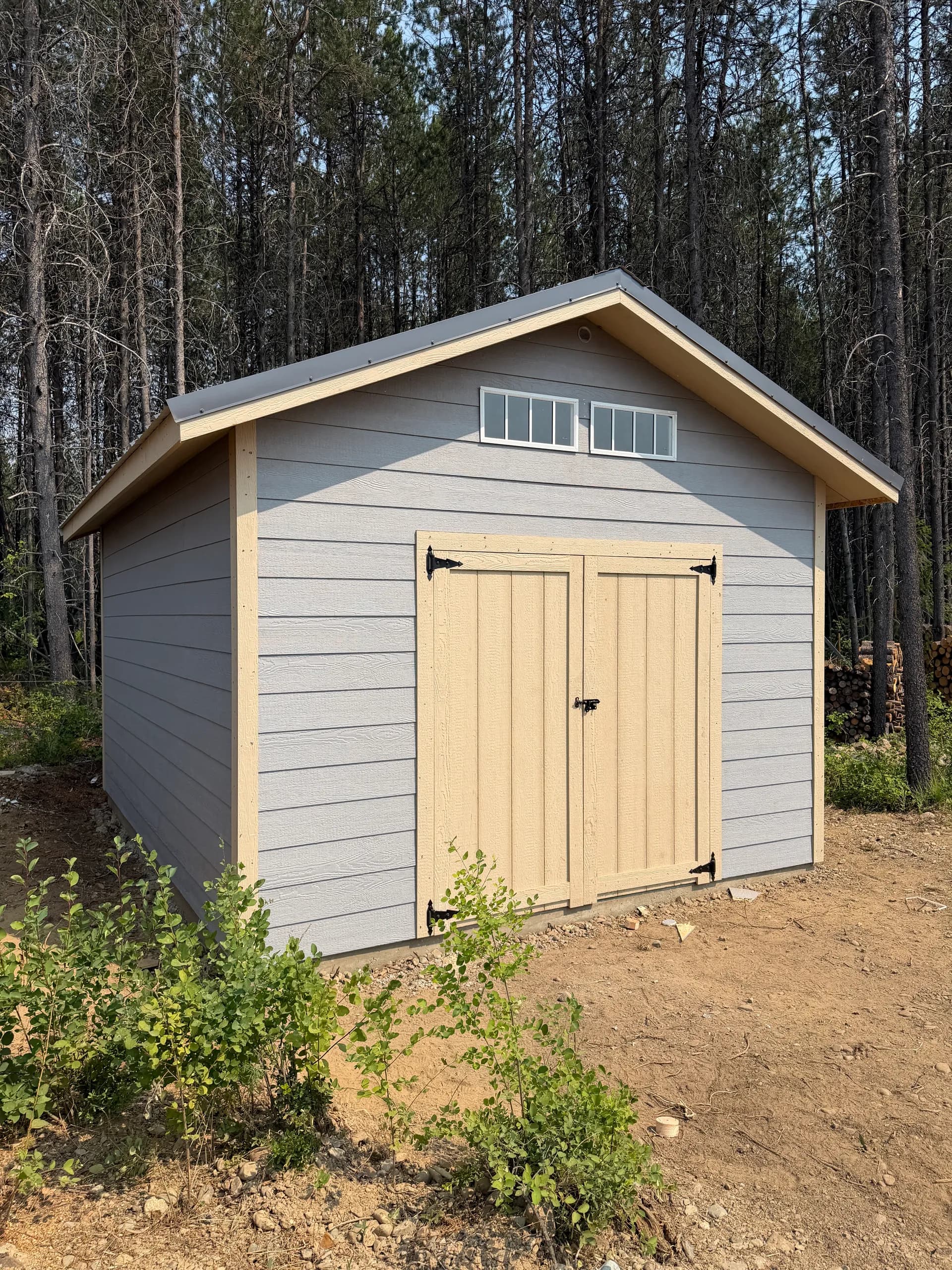 front corner view of 12x16 storage shed with lap siding, transom windows, double shed door