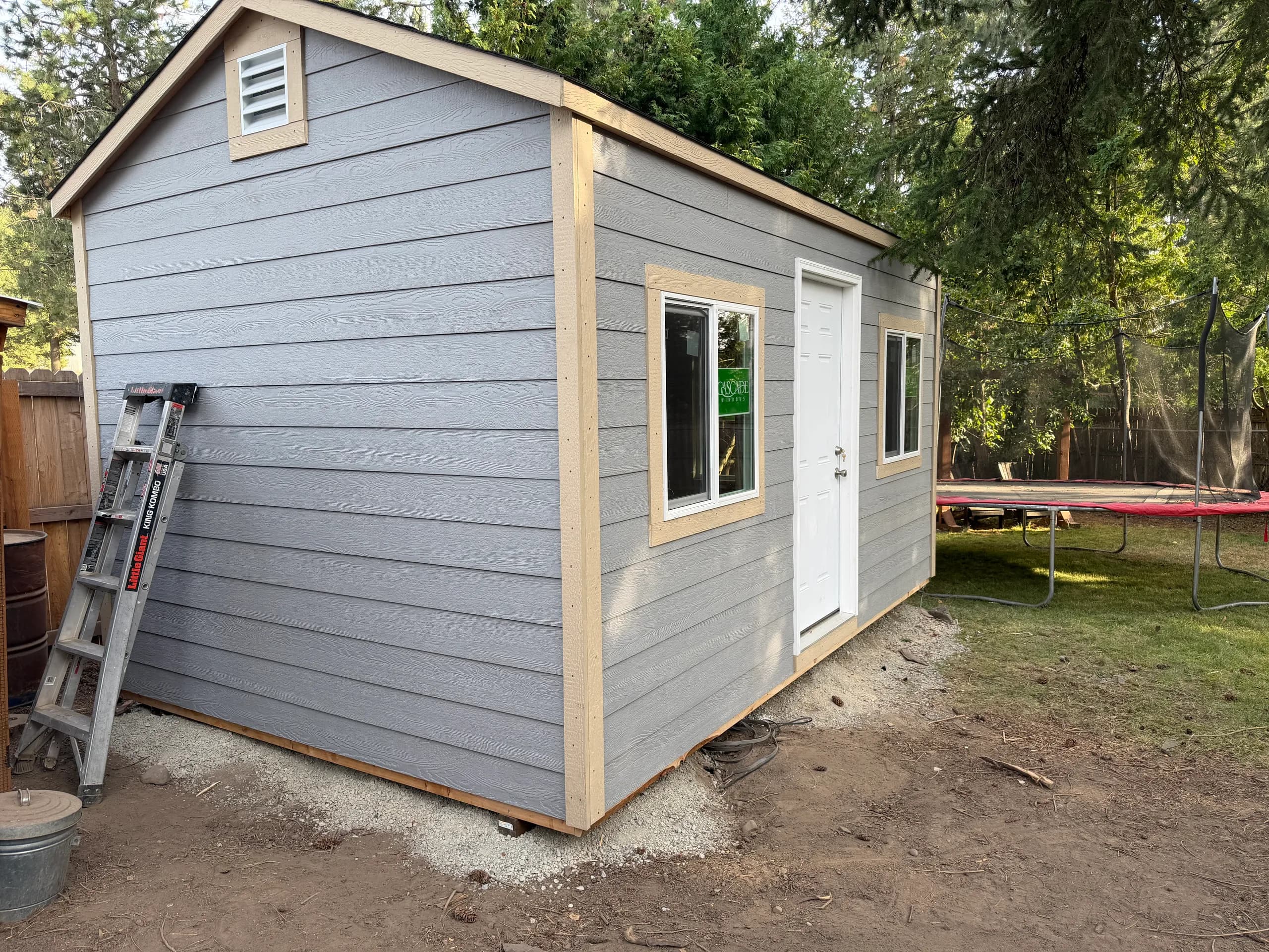 shed with man door, large windows, and lap siding