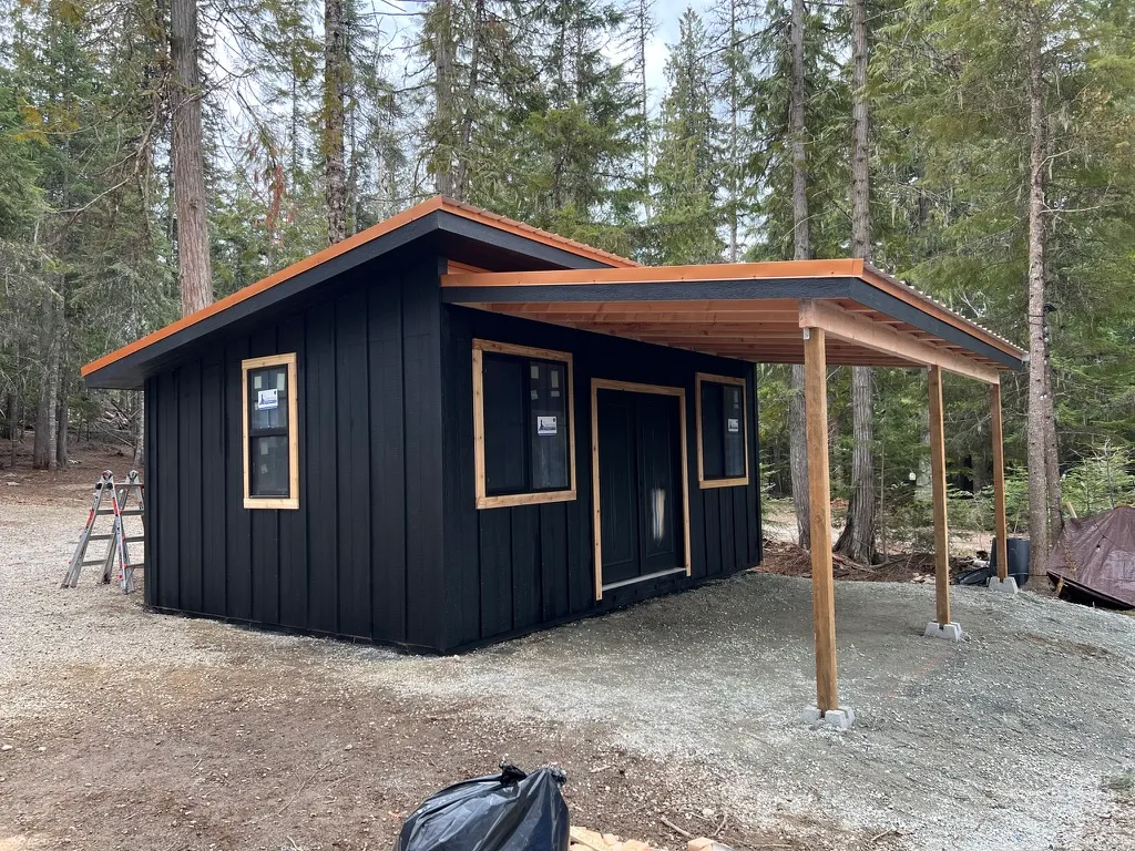 studio shed with lean to and black windows with cedar trim