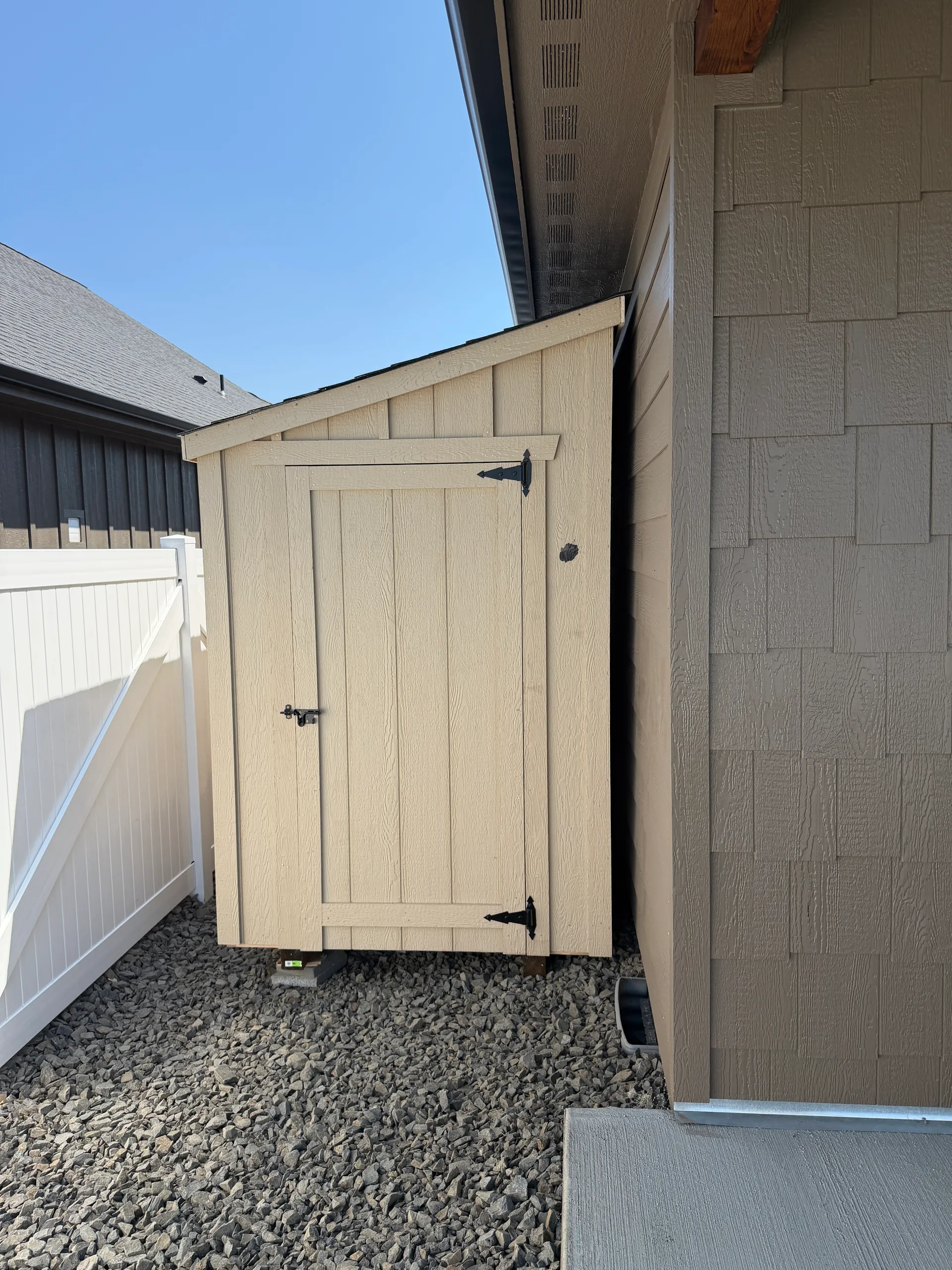 mini modern lean to shed built against house with board and batt siding