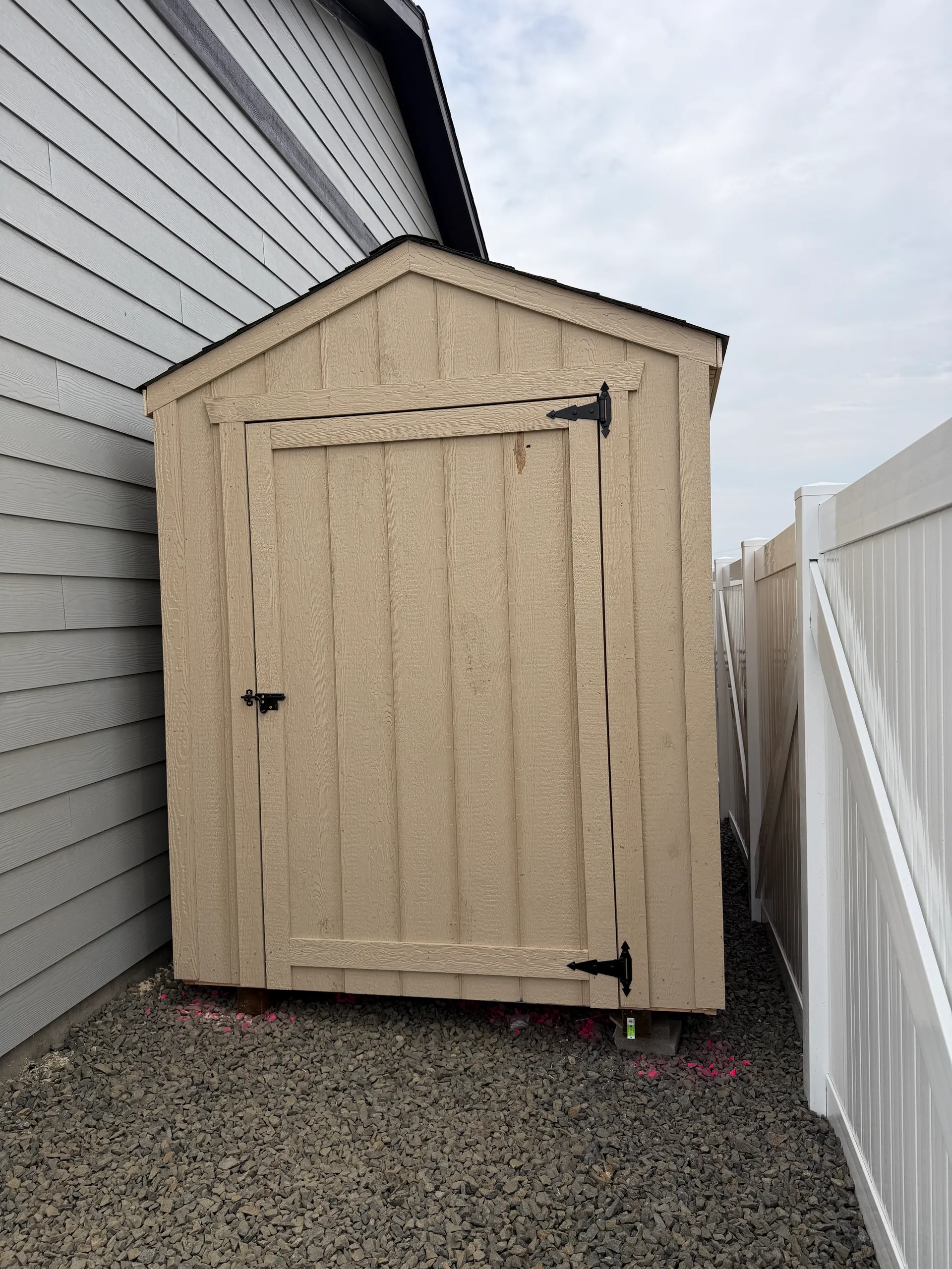 6x10 mini gable shed between shop and fence on sloped gravel